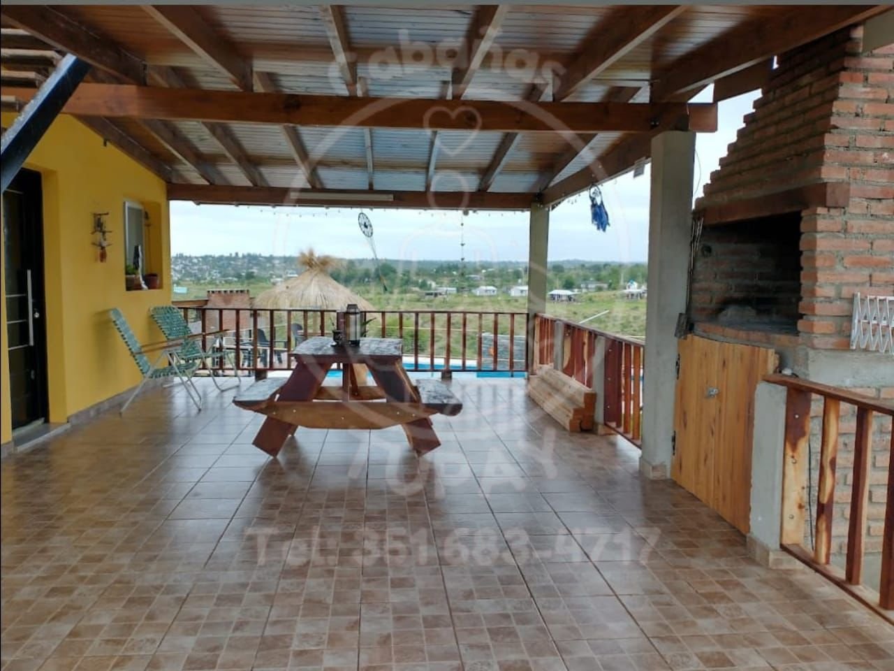 Quincho techado con asador y vistas a las sierras en Cabañas Tupay.