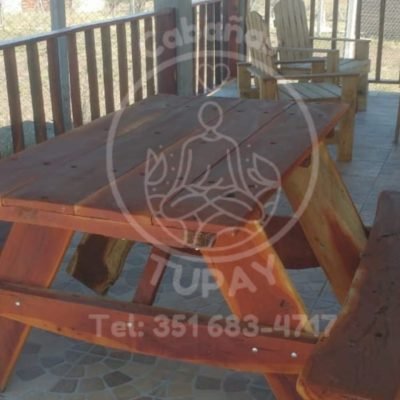 Mesa de madera maciza tipo picnic ubicada en la galería techada, ideal para desayunos o asados al aire libre.