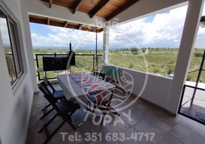 Terraza balcón exclusiva en planta alta con asador chulengo, mesa exterior y vistas panorámicas a las sierras de Córdoba.